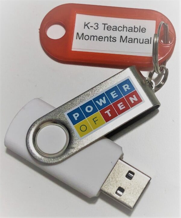A picture of a USB drive with a keyring on it that has an attached label reading K-3 Teachable Moments Manual.
